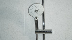 stainless steel shower head on white ceramic tiles