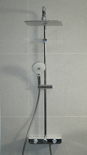 silver shower head mounted on white wall