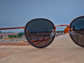 Close-up of a pair of sleek sunglasses resting on a display stand with a blurred background.