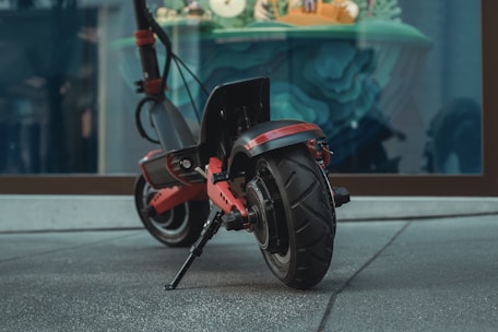 black and red motorcycle parked on gray concrete road