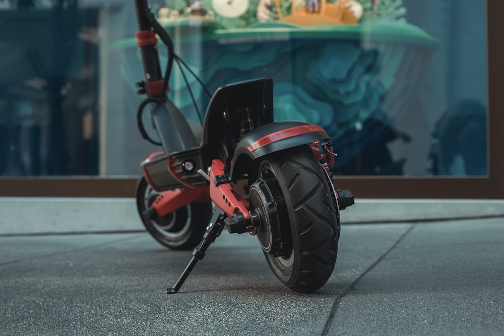 black and red motorcycle parked on gray concrete road