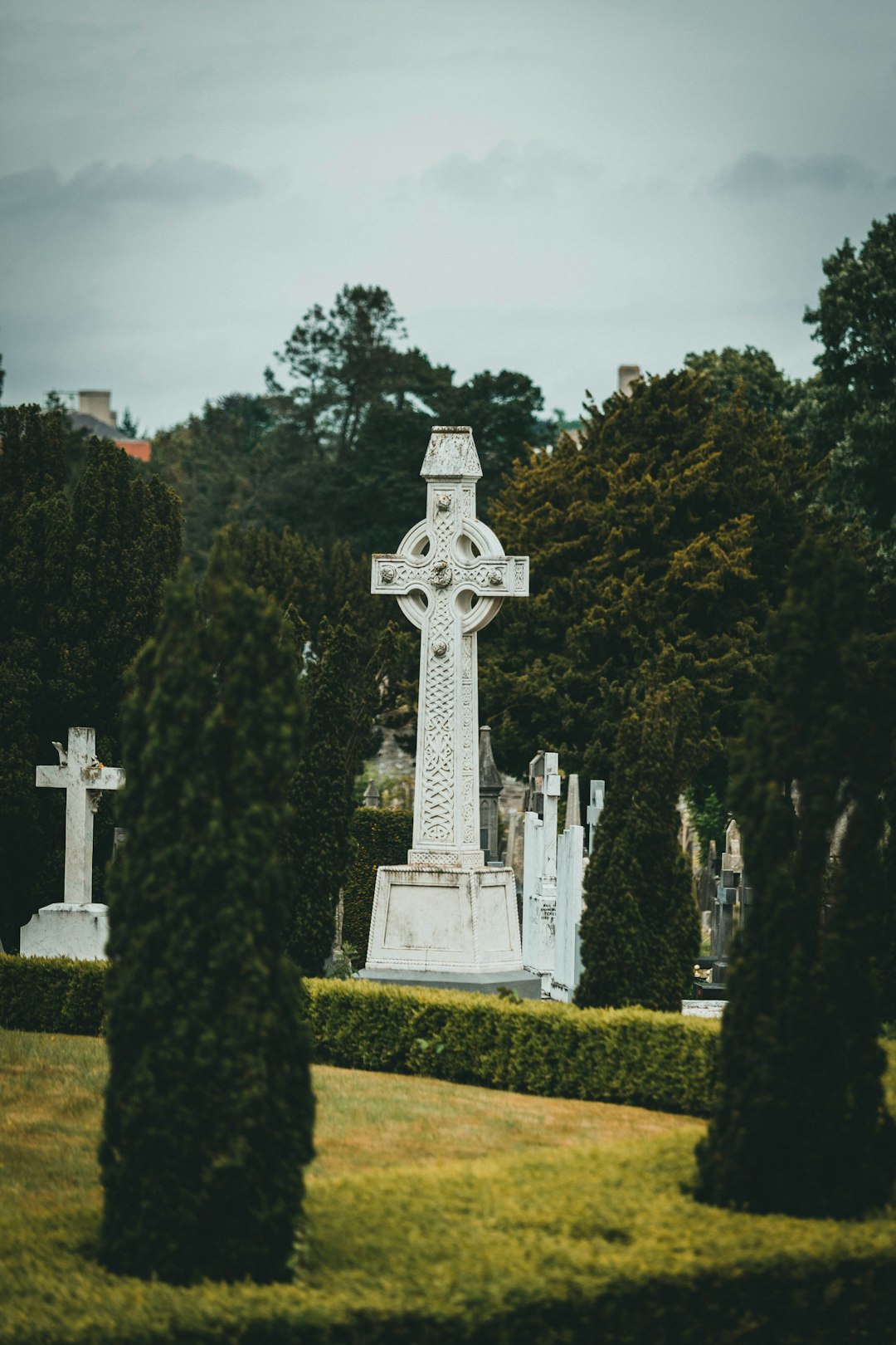 white cross on green grass field during daytime