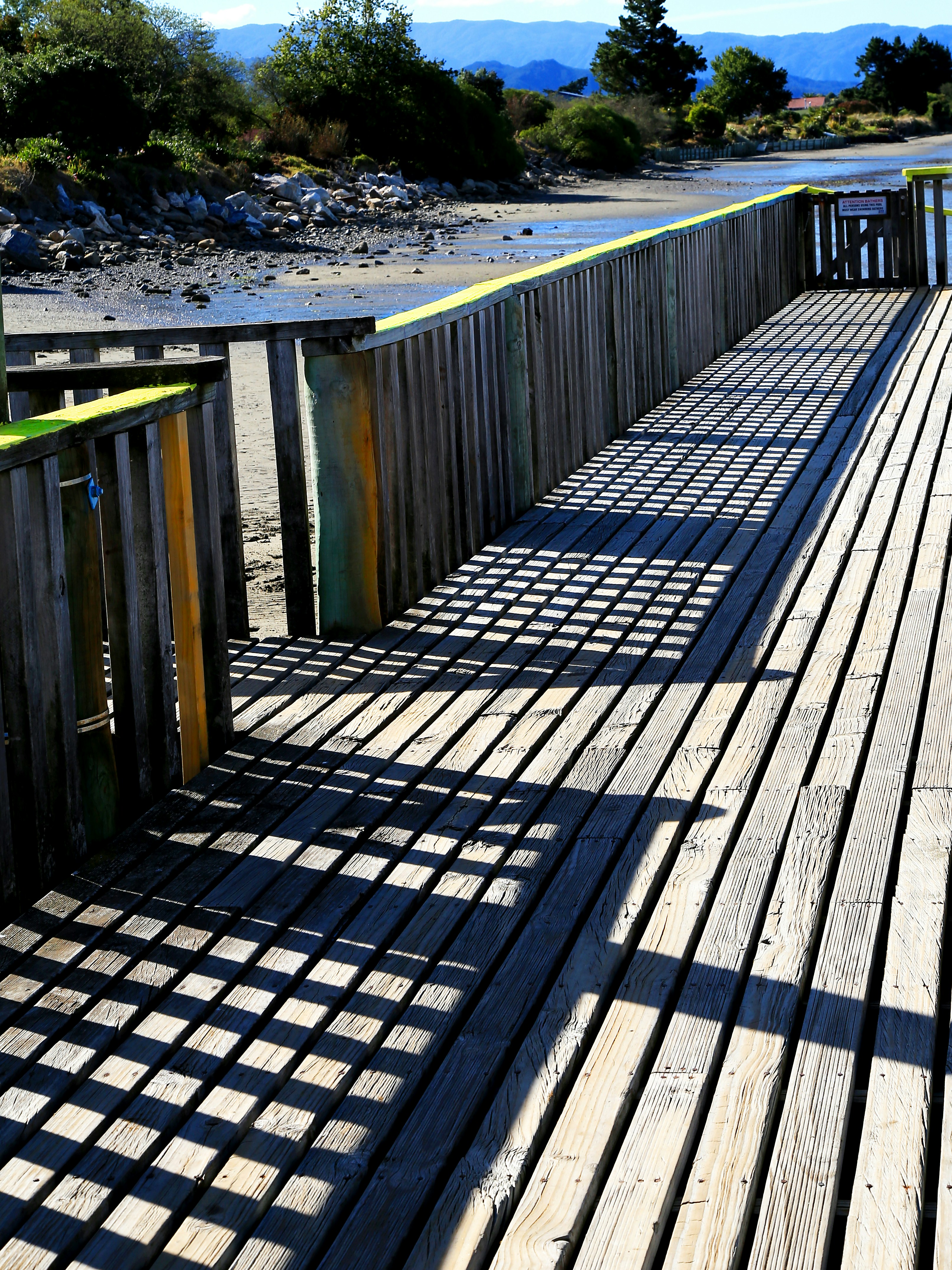 brown wooden fence on gray sand during daytime