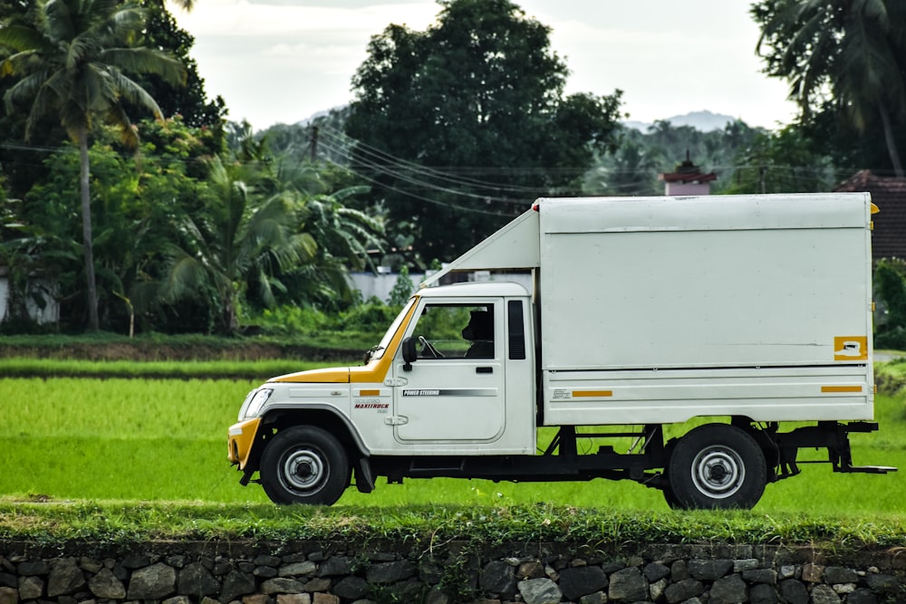 white truck on green grass field during daytime