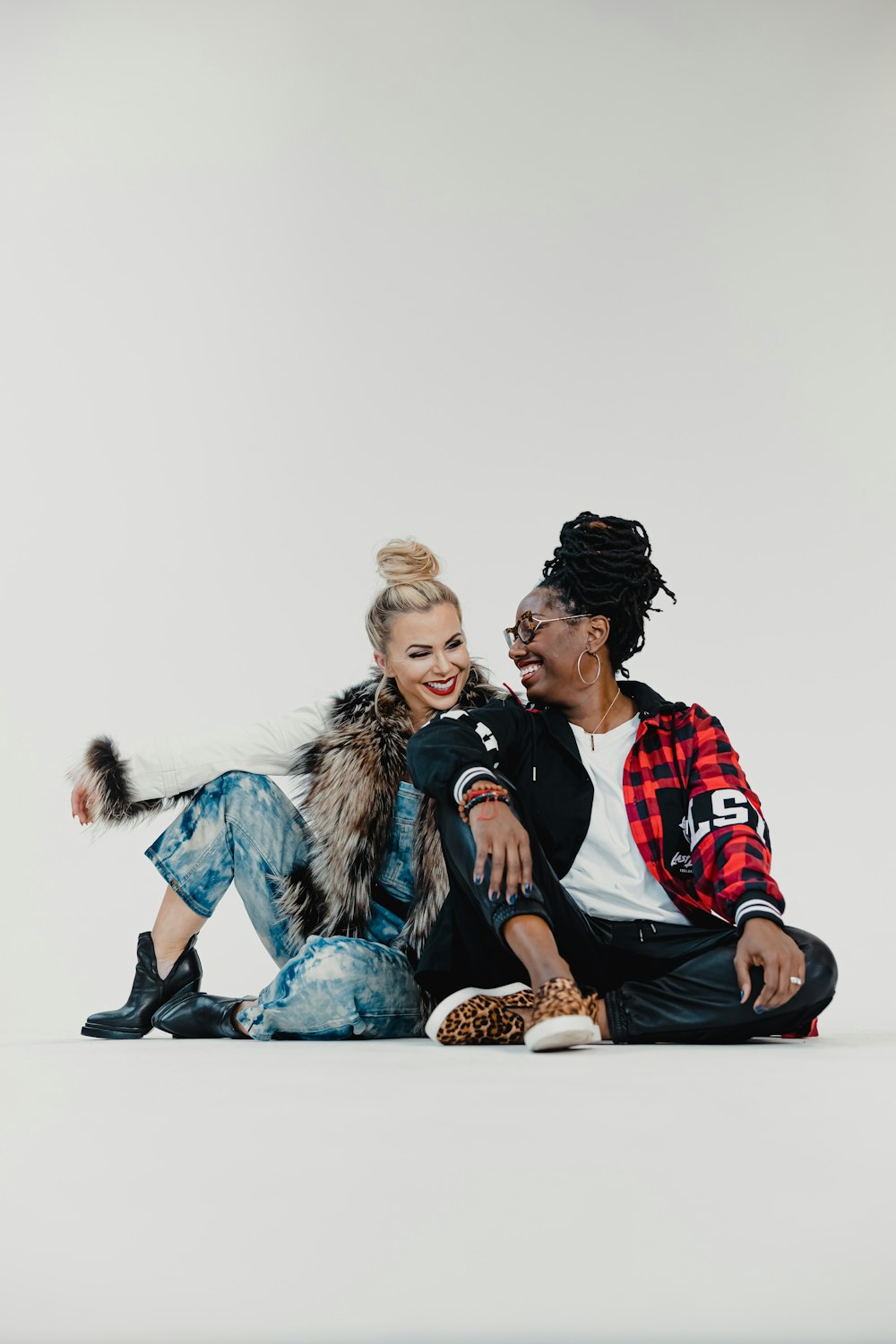 man in red and black jacket sitting beside woman in blue denim jacket