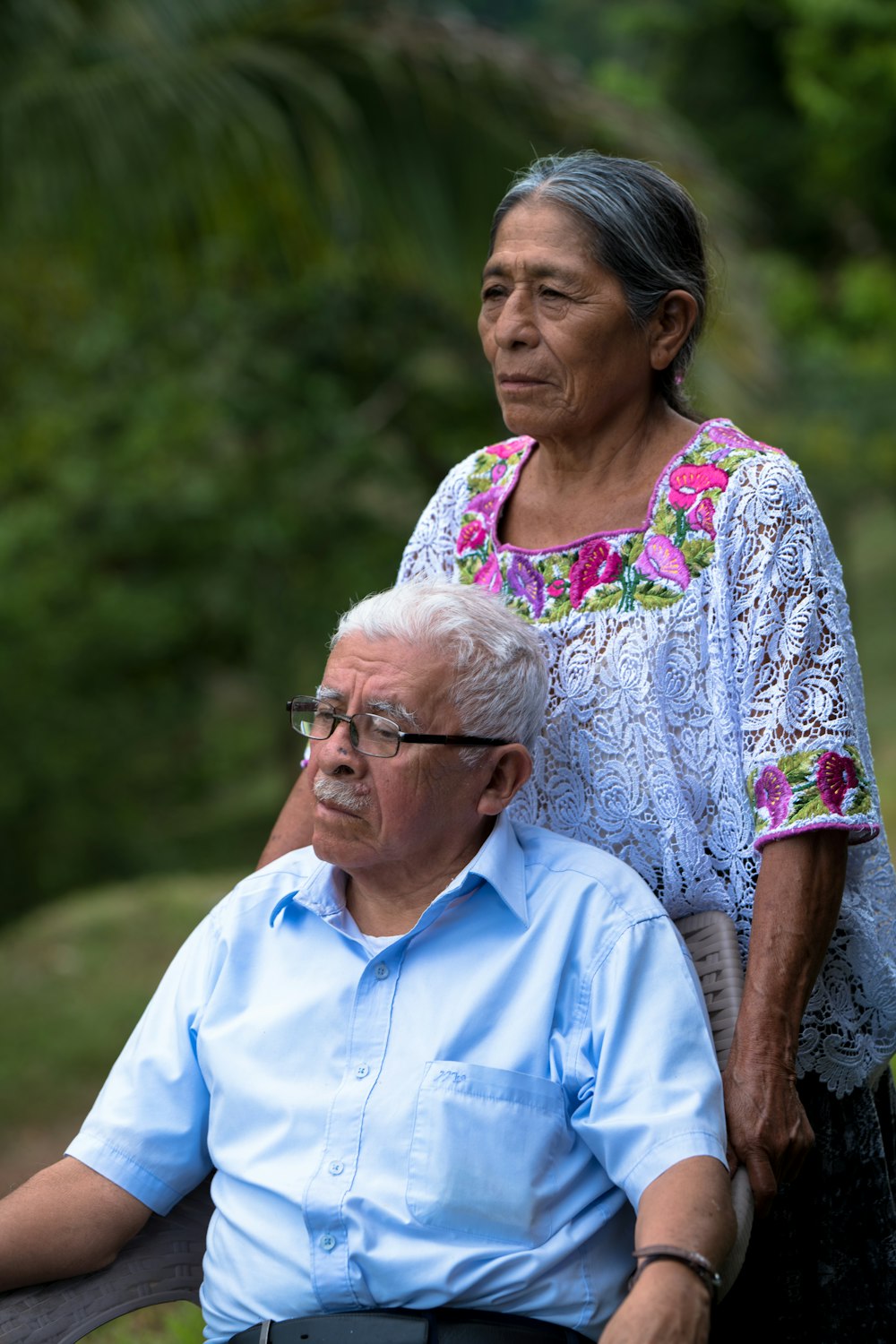 man in blue button up shirt beside woman in white and pink floral shirt