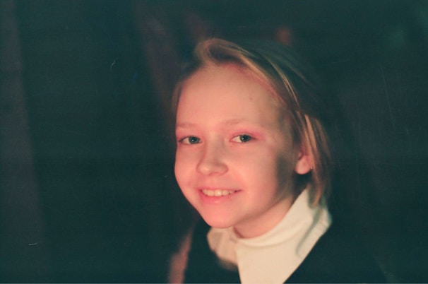 A candid street photograph capturing a fleeting smile under soft white morning light.