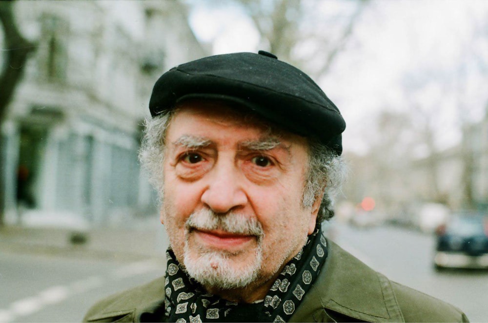 man in black hat and brown coat