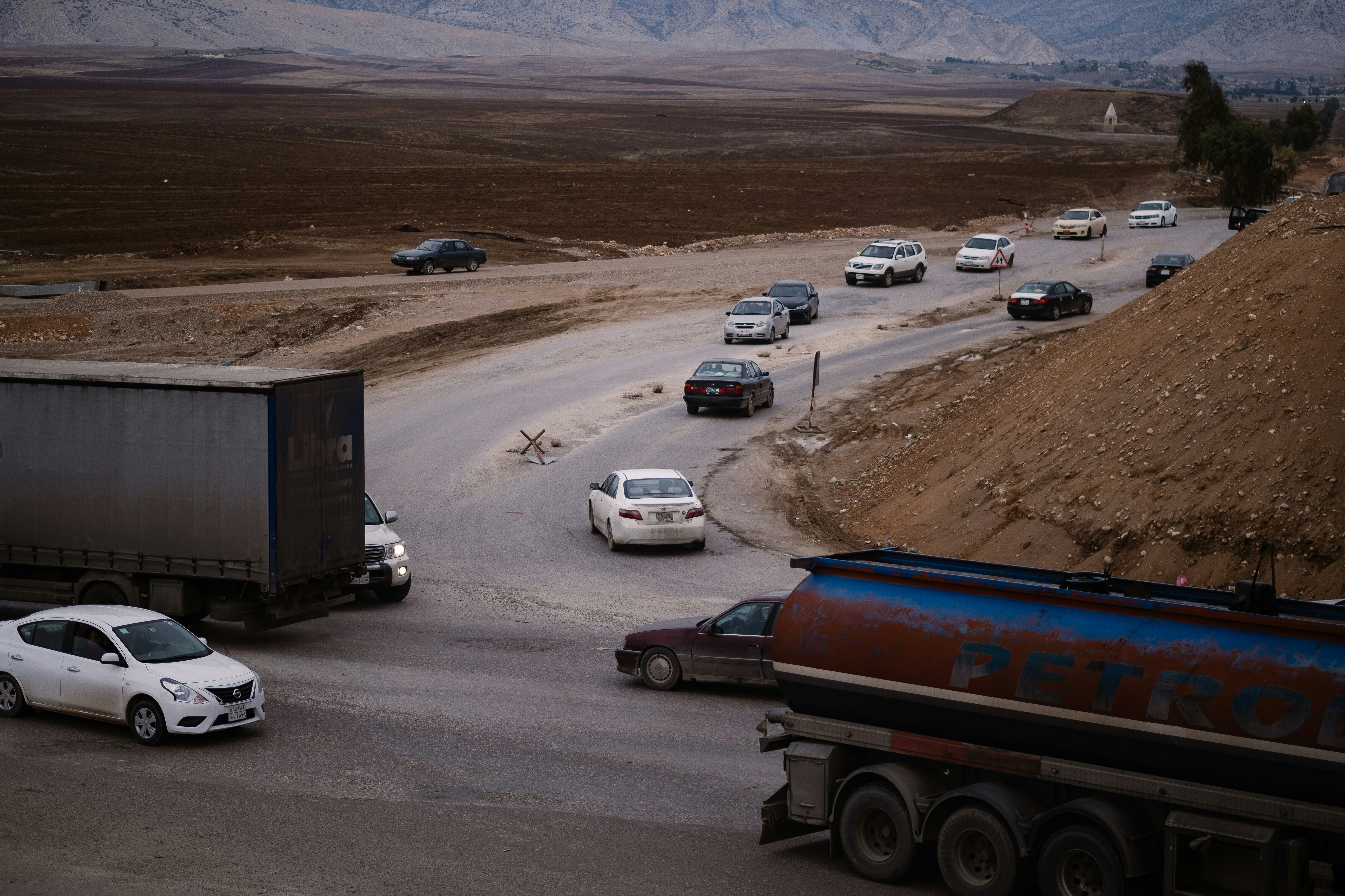 Trucks and cars on a roadway that is under construction, near Duhok in the Kurdistan Region of Iraq.