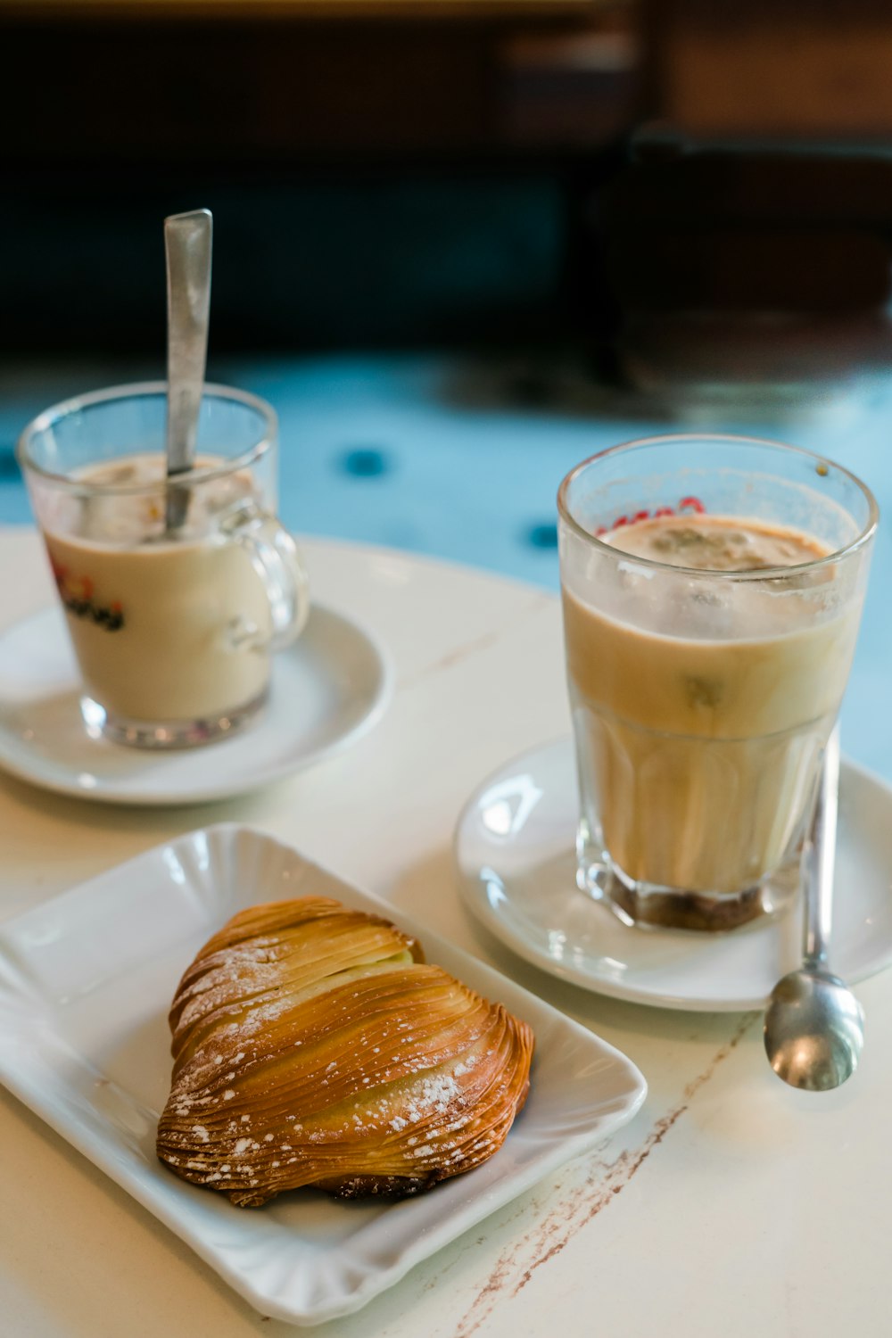 tasse en verre transparent avec liquide brun sur soucoupe en céramique blanche