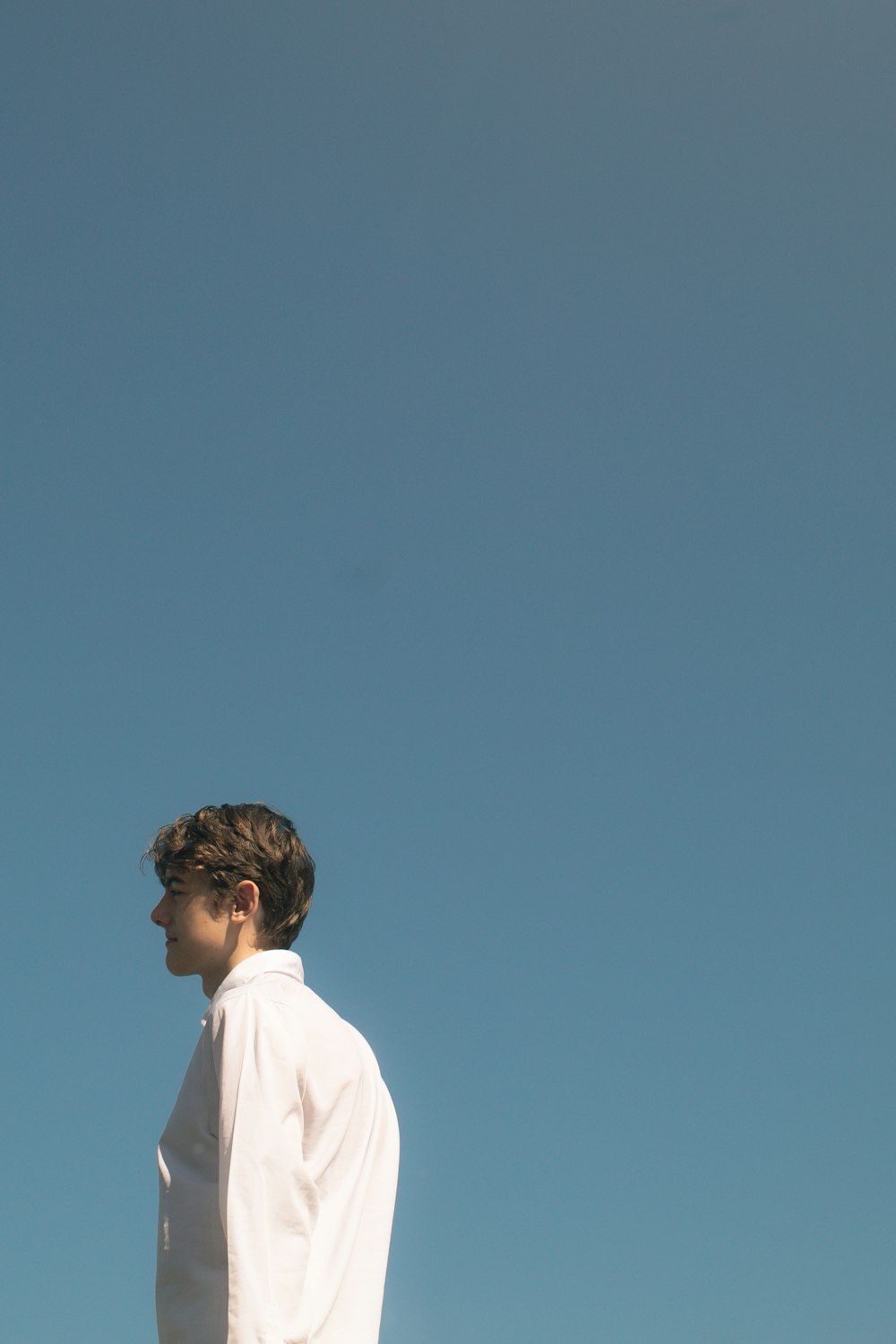 man in white shirt standing under blue sky during daytime