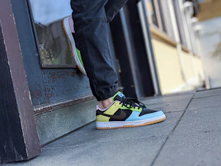 Close-up of colorful streetwear sneakers on a city sidewalk.