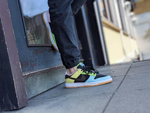 Close-up of colorful streetwear sneakers on a city sidewalk.