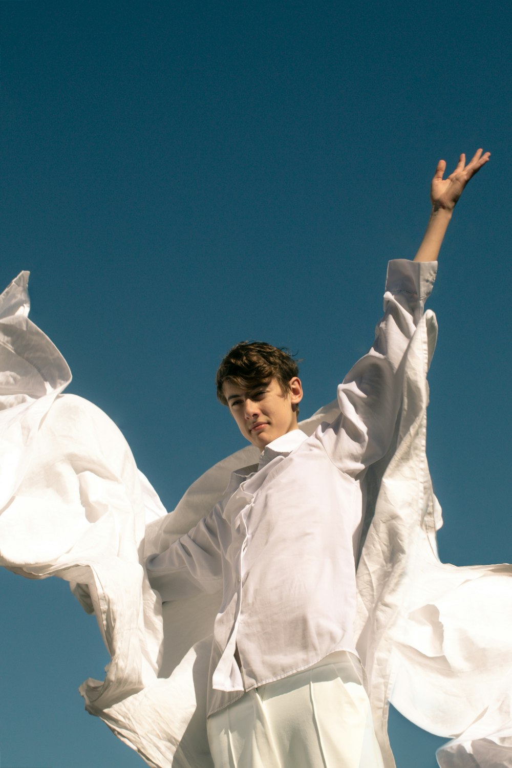 a boy in a white shirt and white pants