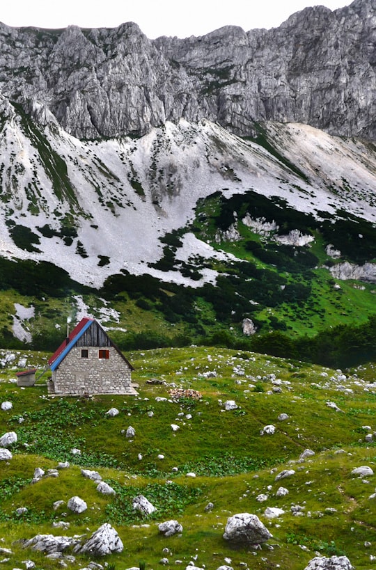 blue and white house on green grass field near mountain during daytime in Bobotov Kuk Montenegro