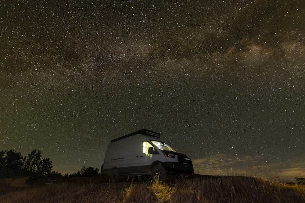 black suv on brown grass field during night time