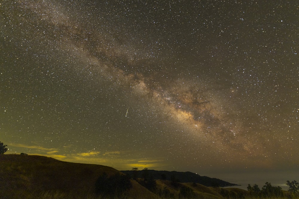 silhouette of mountain under starry night