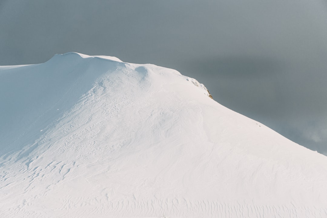 snow covered mountain under gray sky