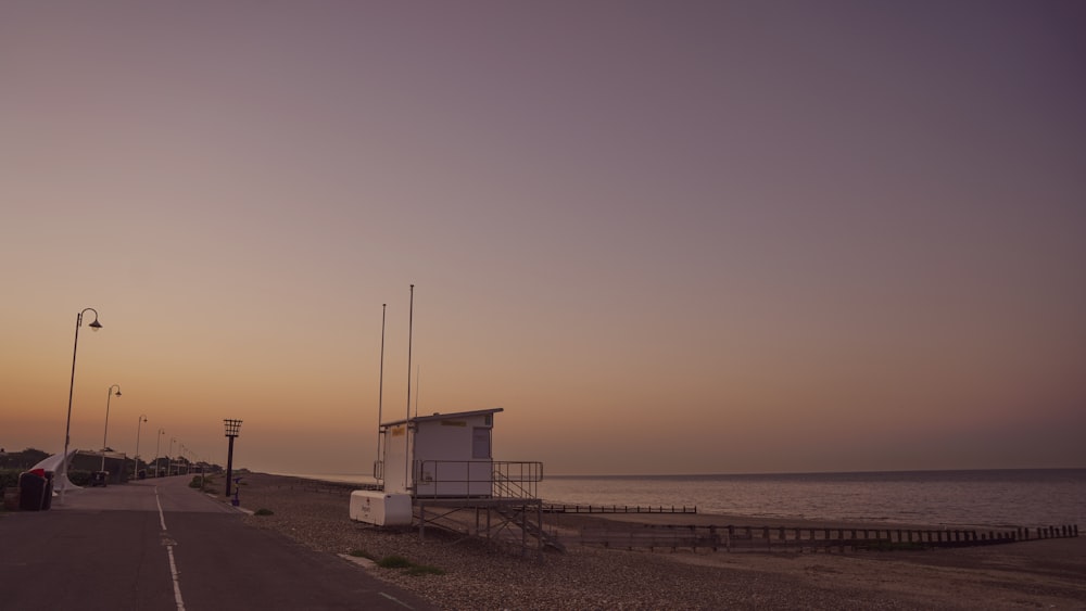 white wooden lifeguard house on beach shore during daytime