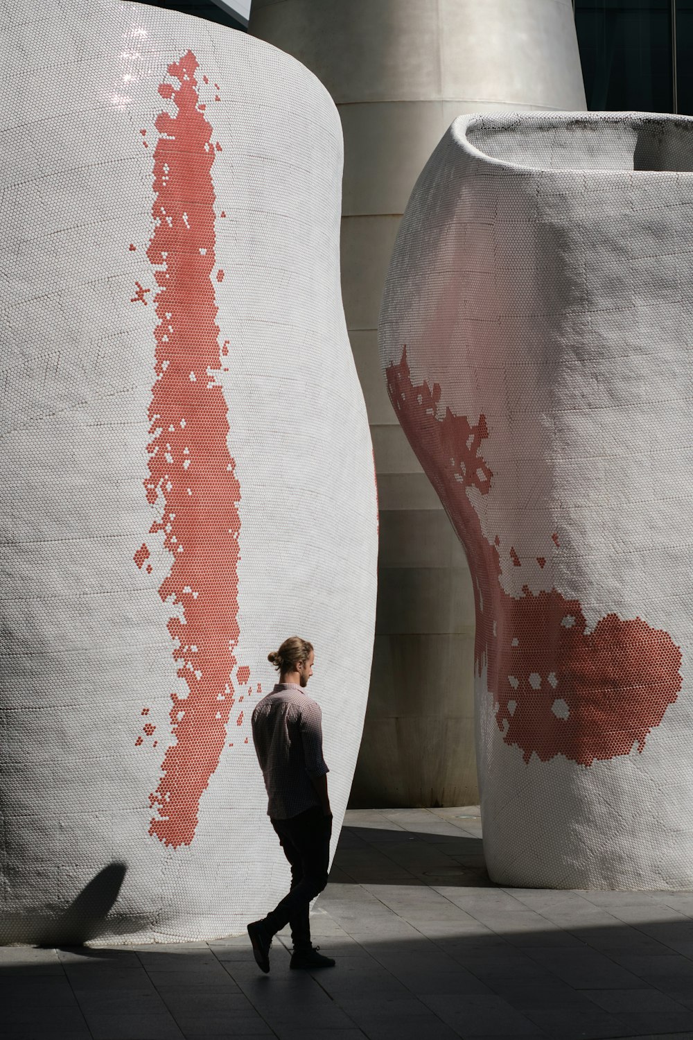 man in black suit standing beside white wall