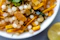 Close-up of a family sharing a meal with a bowl of bright yellow lemon pickle in the center.