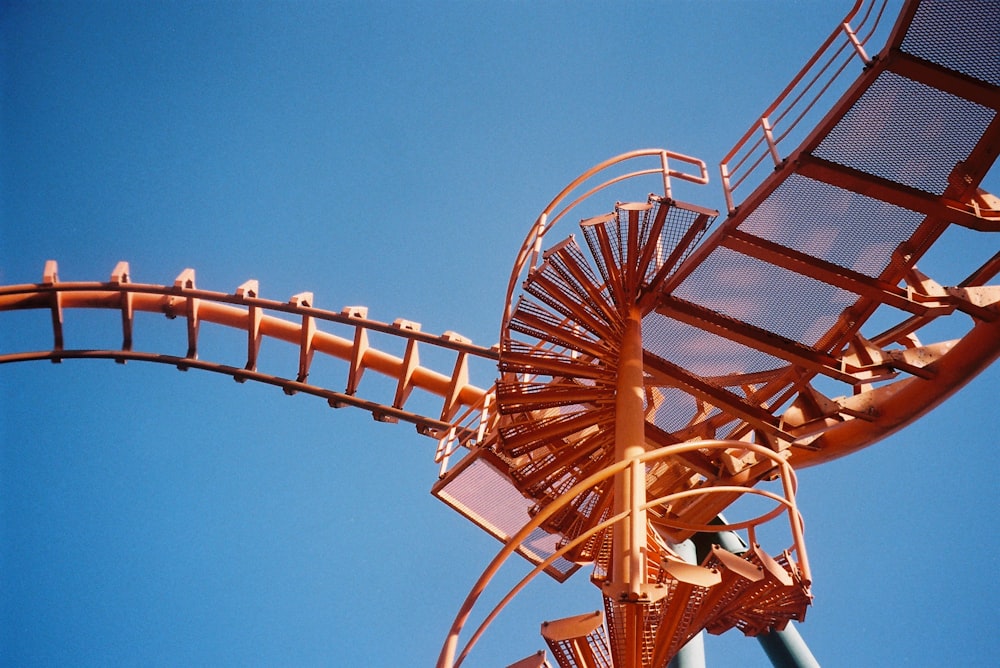 a close up of a roller coaster against a blue sky