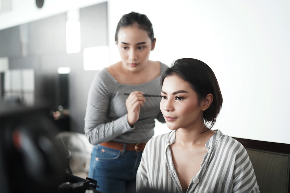 woman in gray v neck long sleeve shirt smiling beside man in gray and white striped