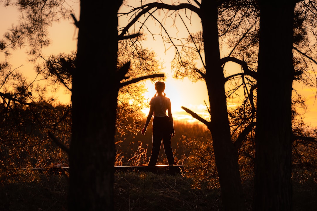 man in brown long sleeve shirt standing in front of brown tree