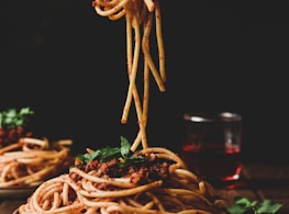 pasta with green leaves on brown ceramic plate