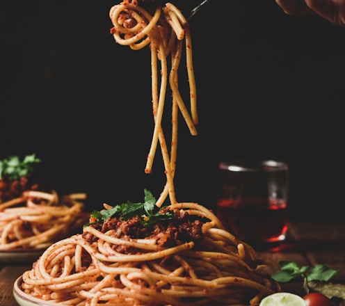 pasta with green leaves on brown ceramic plate