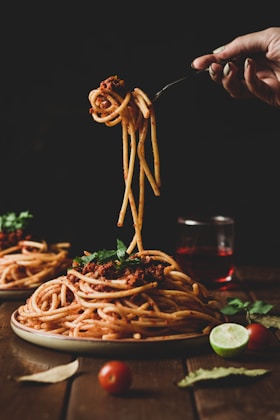 pasta with green leaves on brown ceramic plate