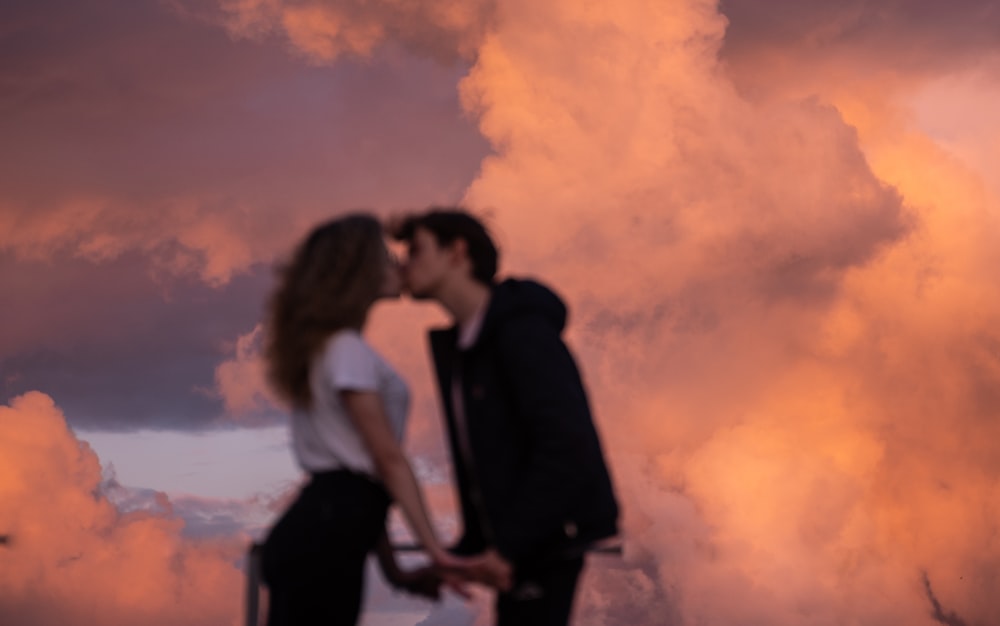 man and woman kissing under cloudy sky during daytime photo – Free Grey ...