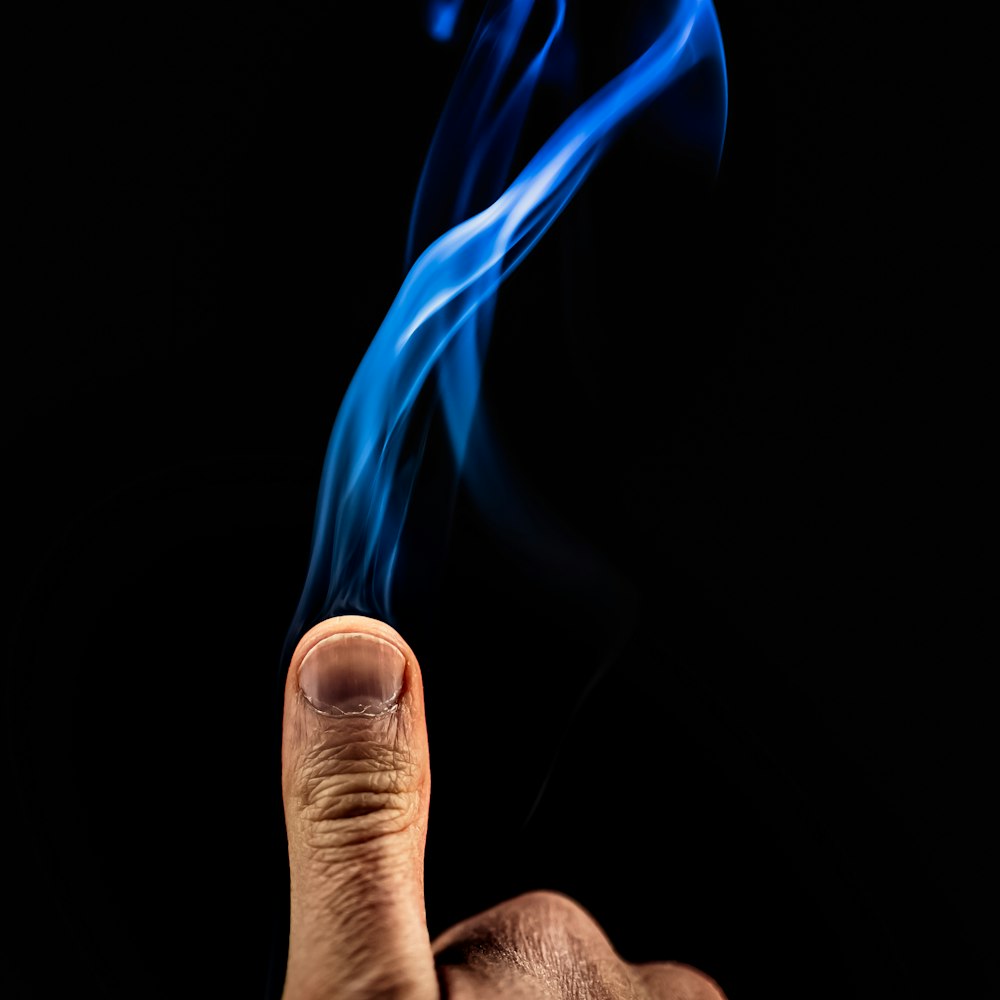person holding blue and white smoke