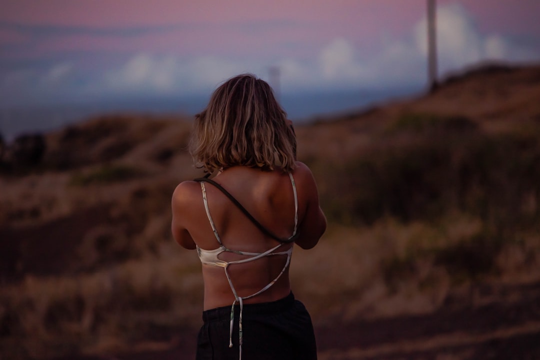 woman in white spaghetti strap top and black pants