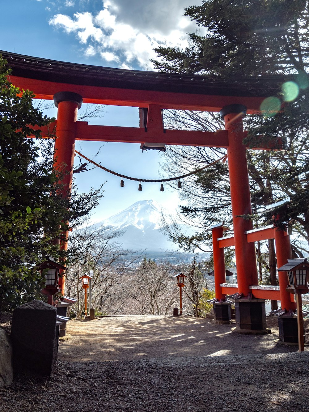 red wooden cross with green trees and mountain in distance