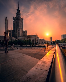 people walking on sidewalk near building during sunset