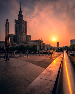 people walking on sidewalk near building during sunset