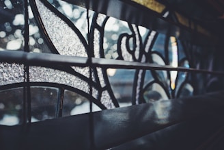 Close-up of a delicate hand-painted glass panel glowing softly in natural light