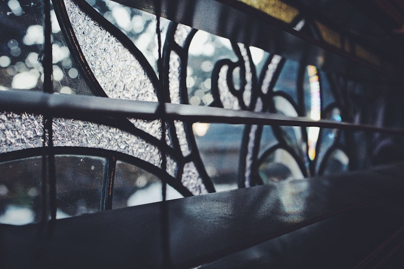 Close-up of a delicate hand-painted glass panel glowing softly in natural light