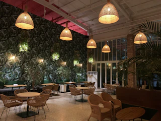 Warm, sunlit interior with hanging macramé decorations and lush green plants creating a cozy boho beach vibe.