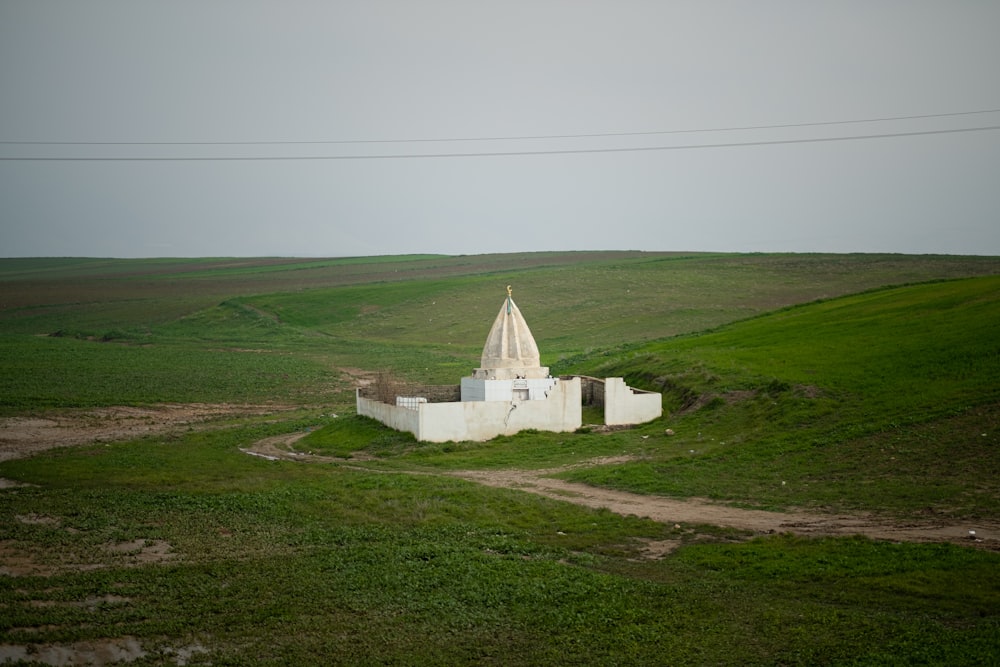 white concrete building on green grass field under white sky during daytime