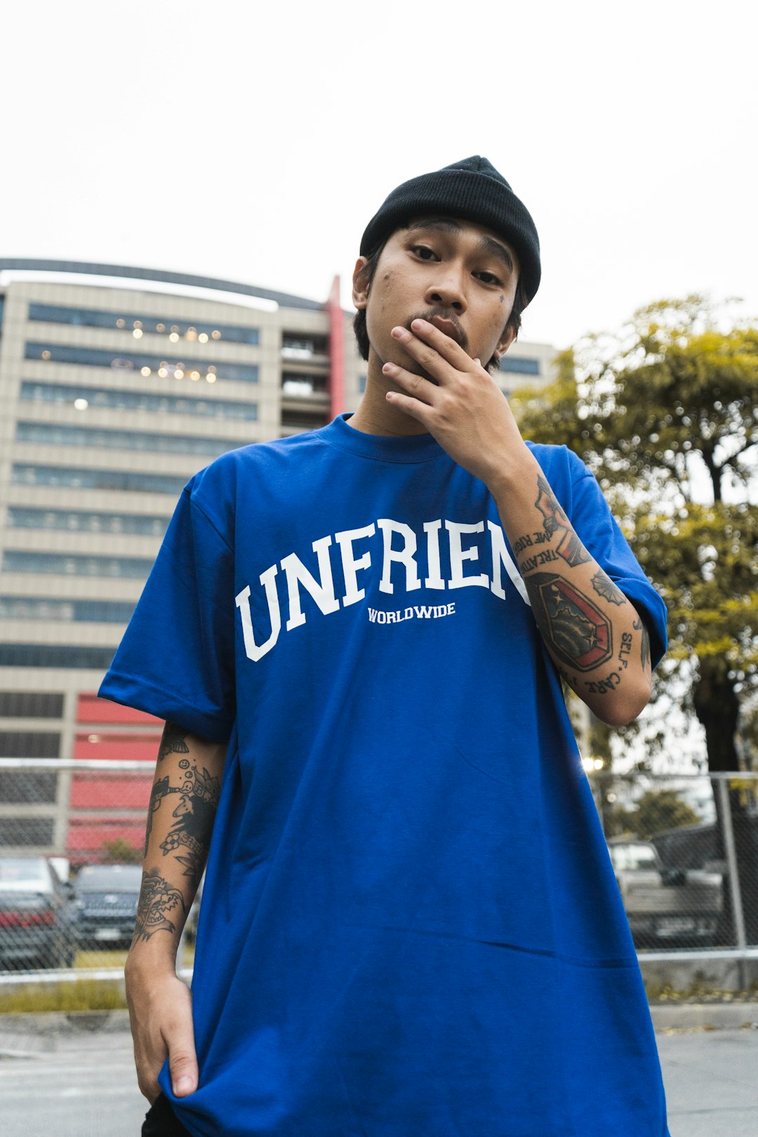 man in blue and white crew neck t-shirt standing near building during daytime