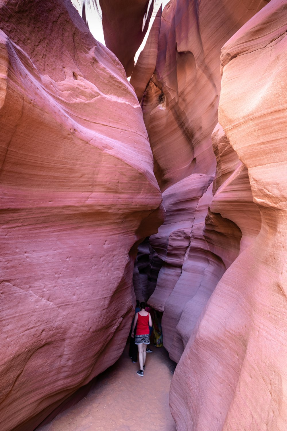 person in blue jacket climbing brown rock formation during daytime