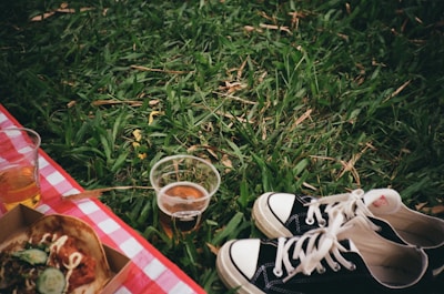 A picnic scene showing eco cups alongside healthy snacks and a blanket.