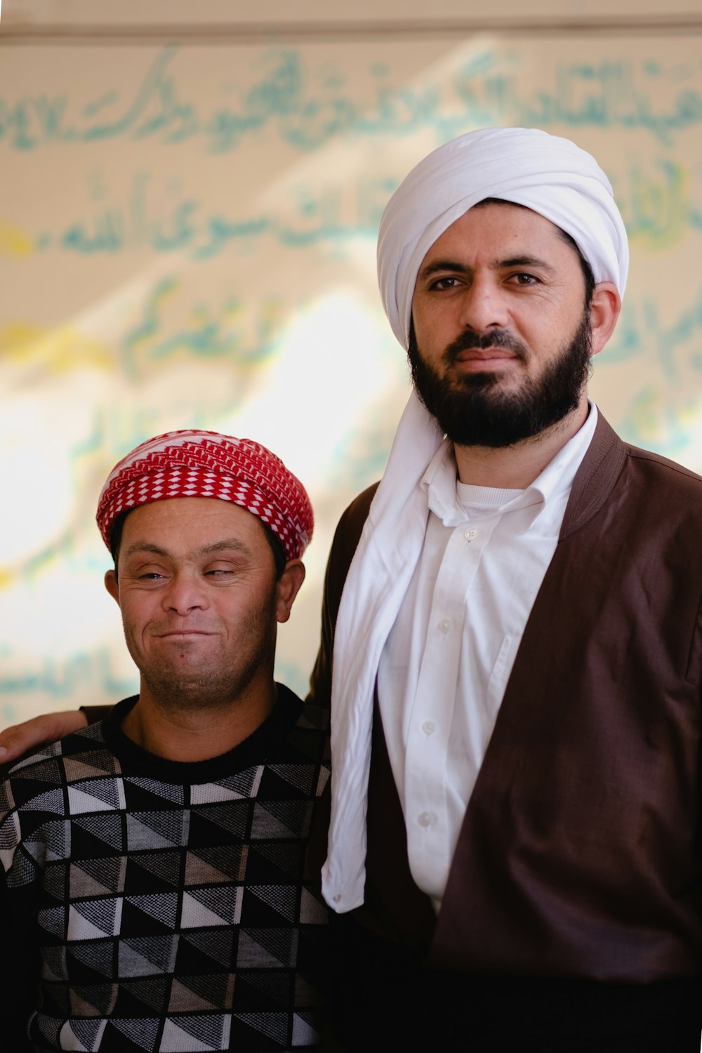 Homme en thobe blanc et foulard imprimé à carreaux noir et blanc