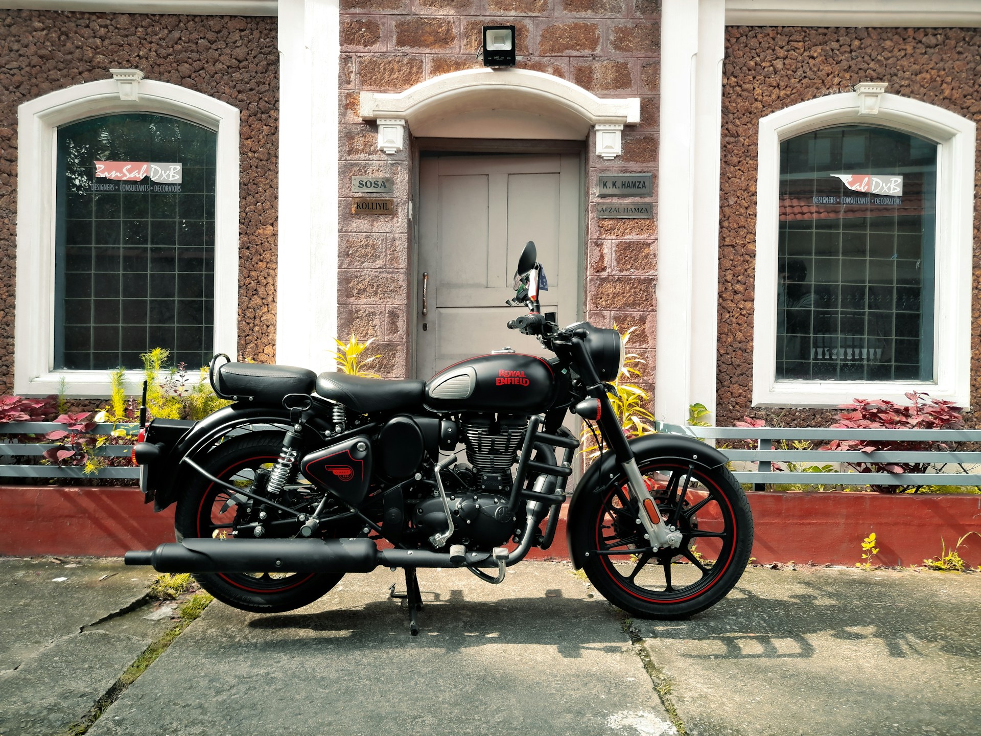 black and silver cruiser motorcycle parked beside brown concrete building during daytime