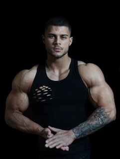 man in black tank top with tattoo on arm