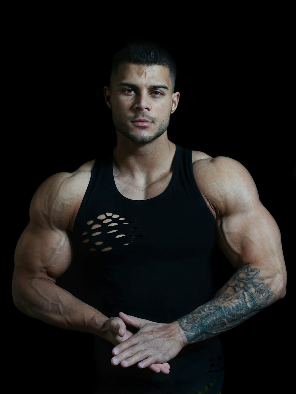 Mann in schwarzem Tanktop mit Tattoo am Arm