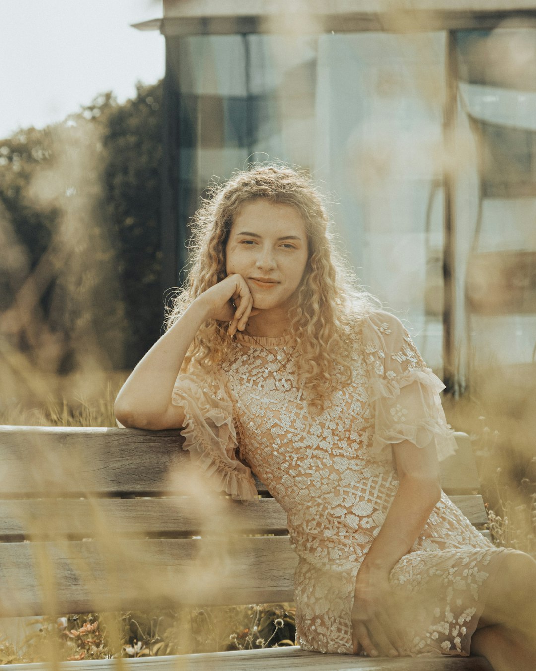 woman in white dress sitting on brown wooden bench