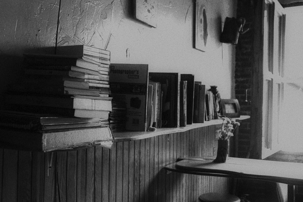 grayscale photo of books on shelf